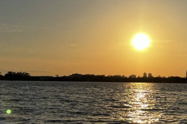 A sunset over a body of water seen from a charter boat