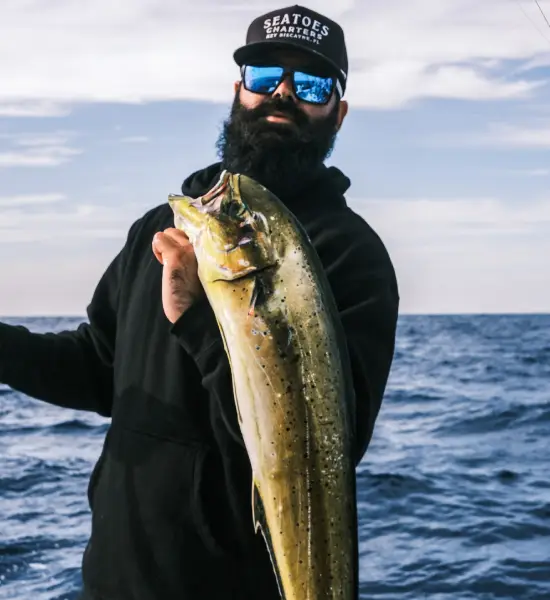 A person holding a fish during a fishing charter