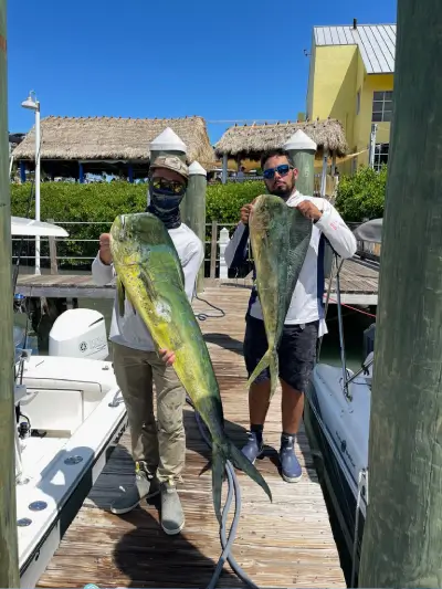A person sitting on a boat with a fishing pole during a Miami trip