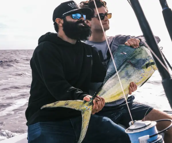 A fisherman on a dock with several fish caught in Brickell