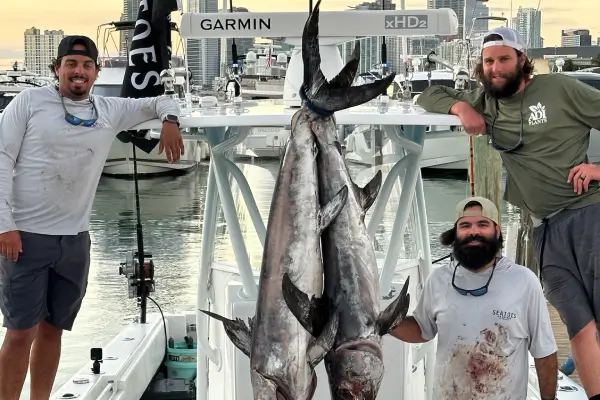 A fisherman sitting on a dock with several fish in Coral Gables