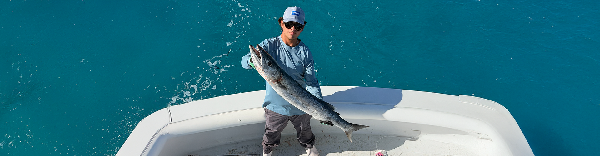A fisherman holding a large fish caught in Miami