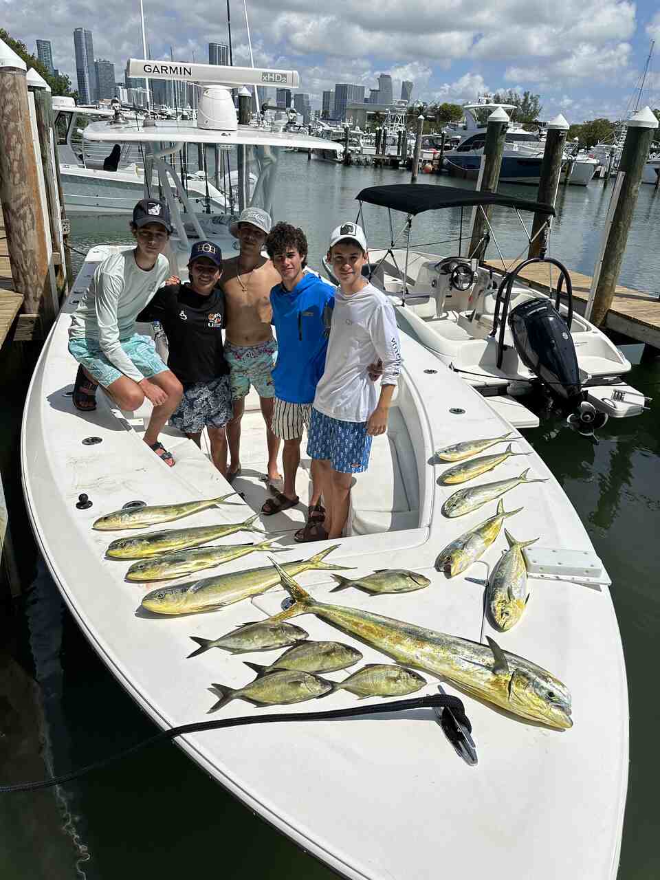 A group on a boat with fish caught during a Miami fishing tour