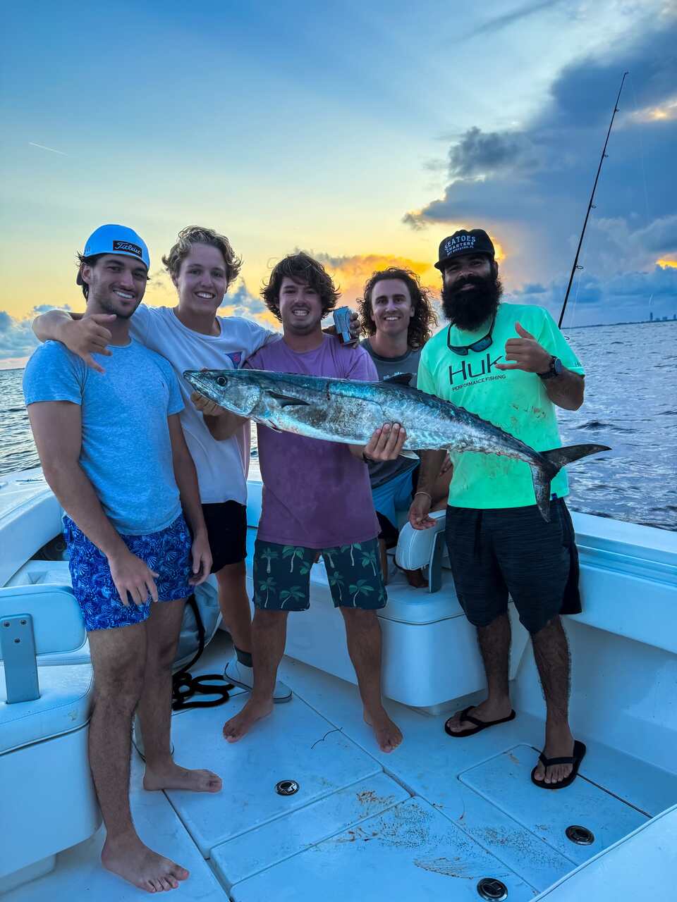 A group of men holding fish on a boat in North Miami