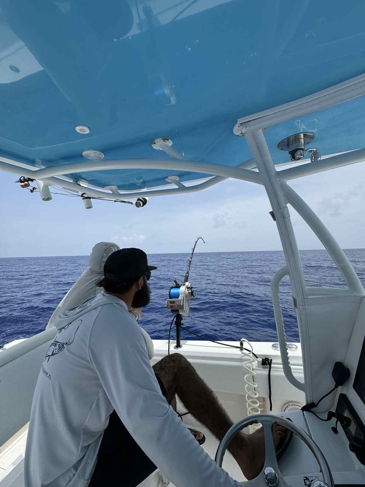 An angler sitting on a boat with a fishing pole in Coral Gables