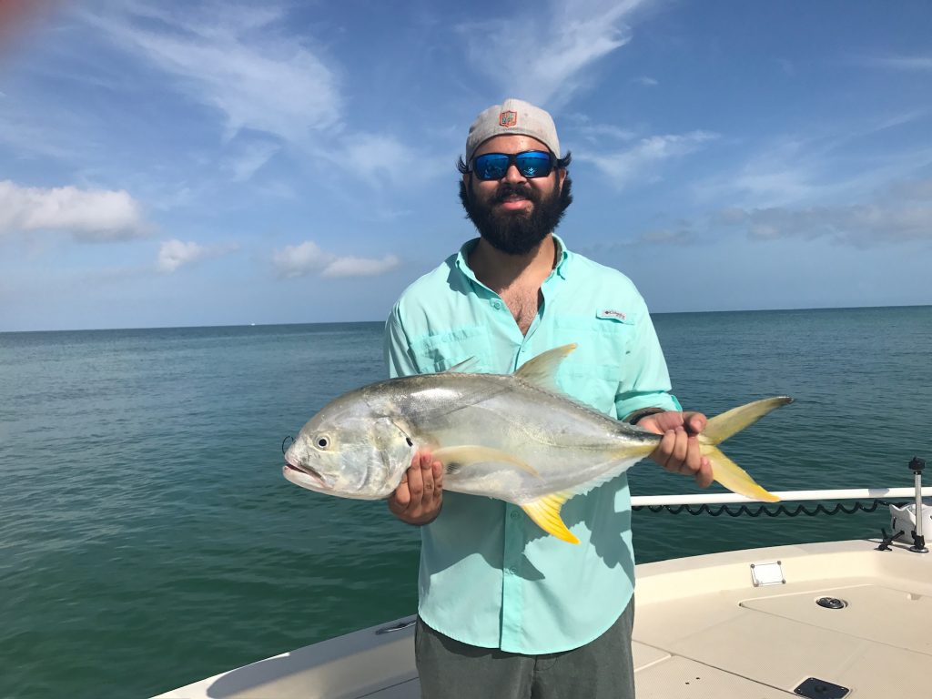 A person showing off a fish caught in Coral Gables