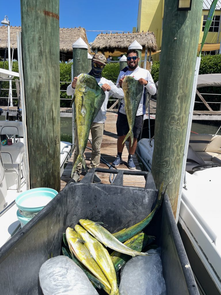 Two men displaying a large fish caught during a Miami fishing tour