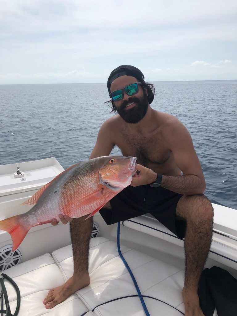 An angler displaying their catch on a Coral Gables charter