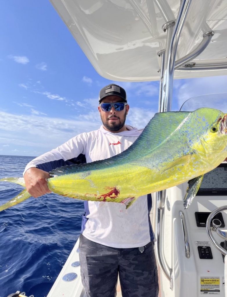 An angler with a fish on a boat during a guided trip