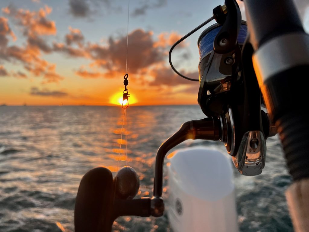 A fishing rod and a sunset over the water in Coral Gables