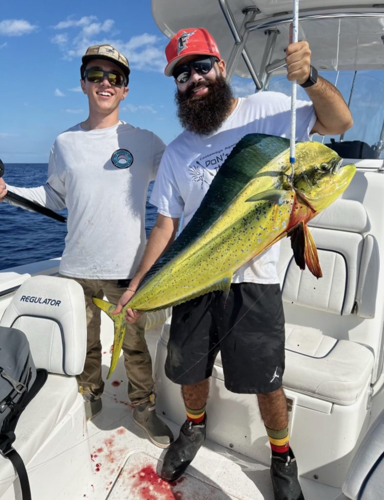 Two men posing with their catch in Miami