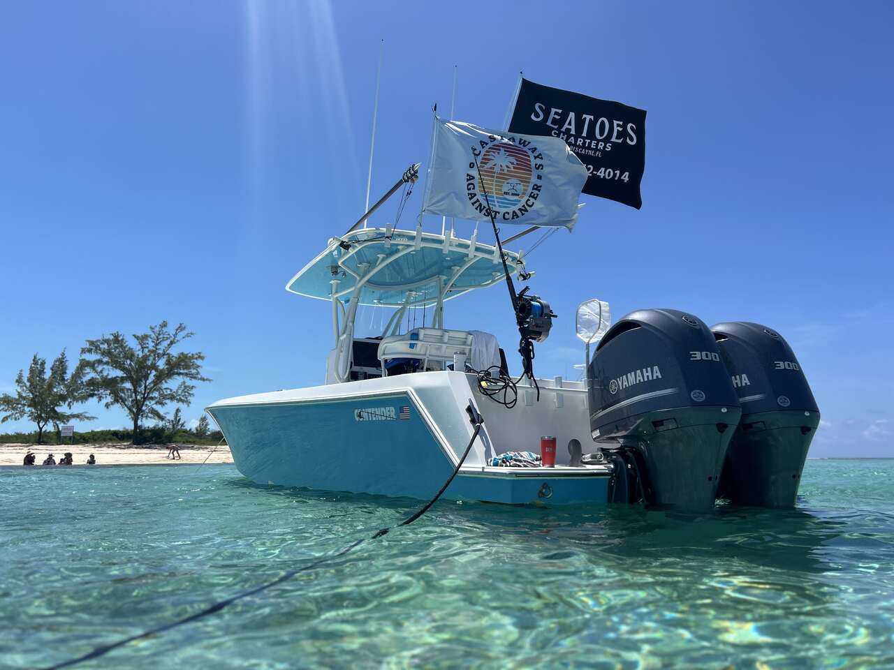An angler sitting on a dock with a fish and a pile of fish