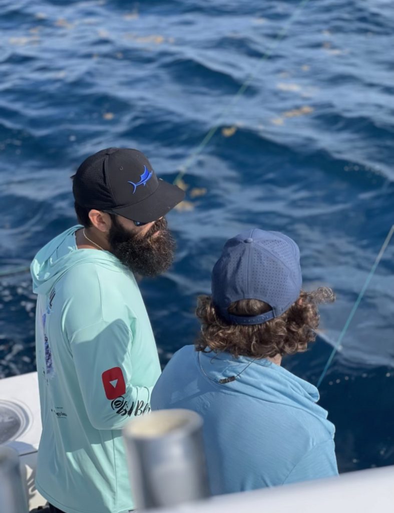 Two men on a boat enjoying a fishing trip in Coral Gables