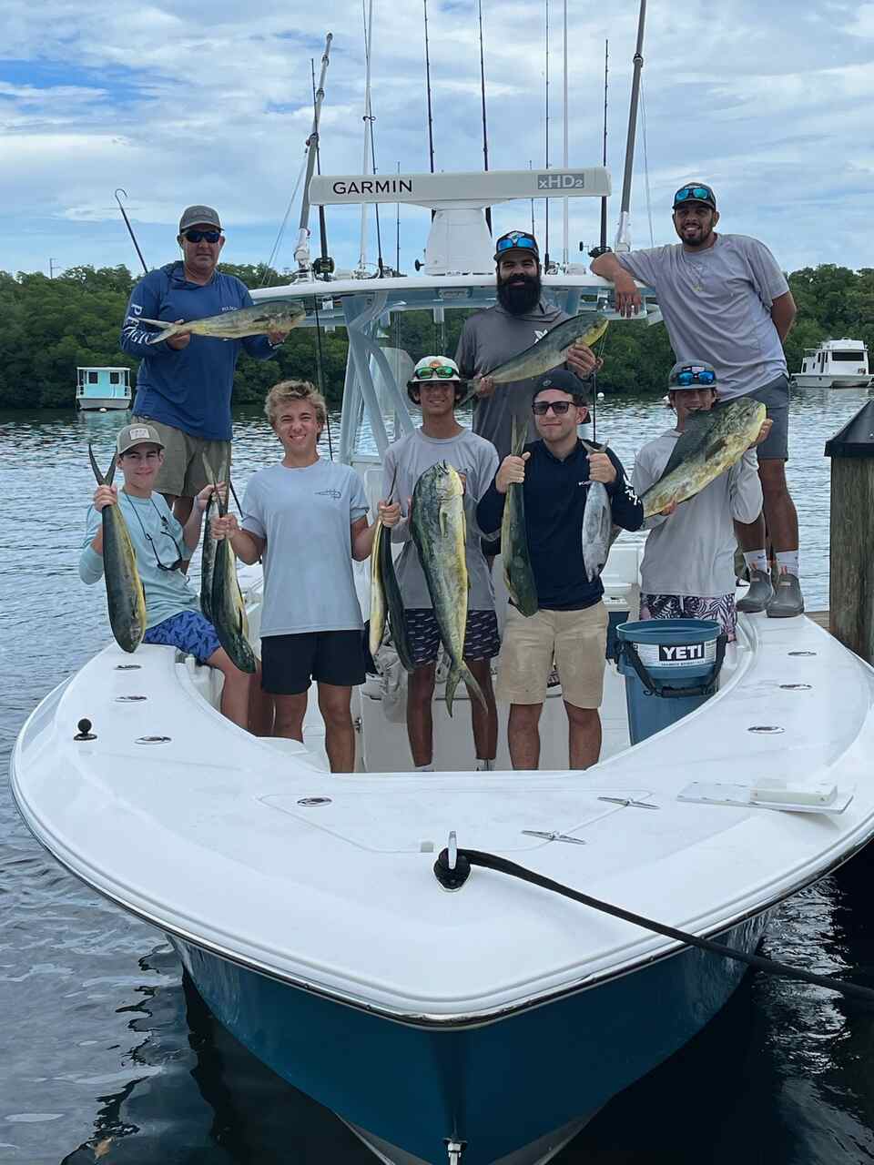 A group holding fish on a charter boat in North Miami