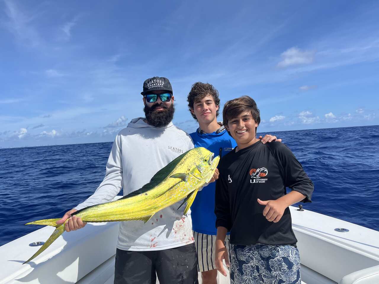 A group of men with a yellow fish on a boat in Miami