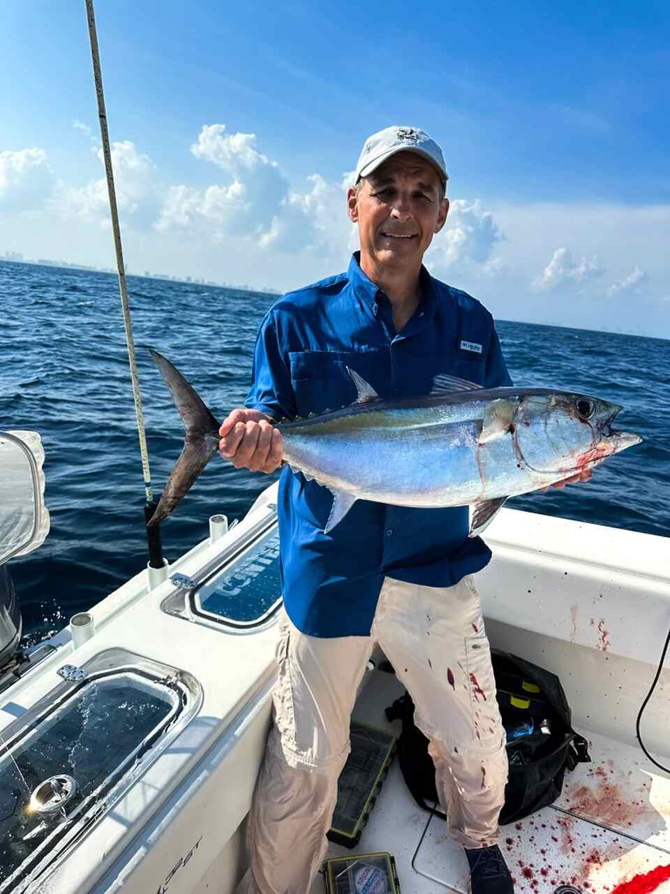An angler holding a fish on a charter boat in Brickell