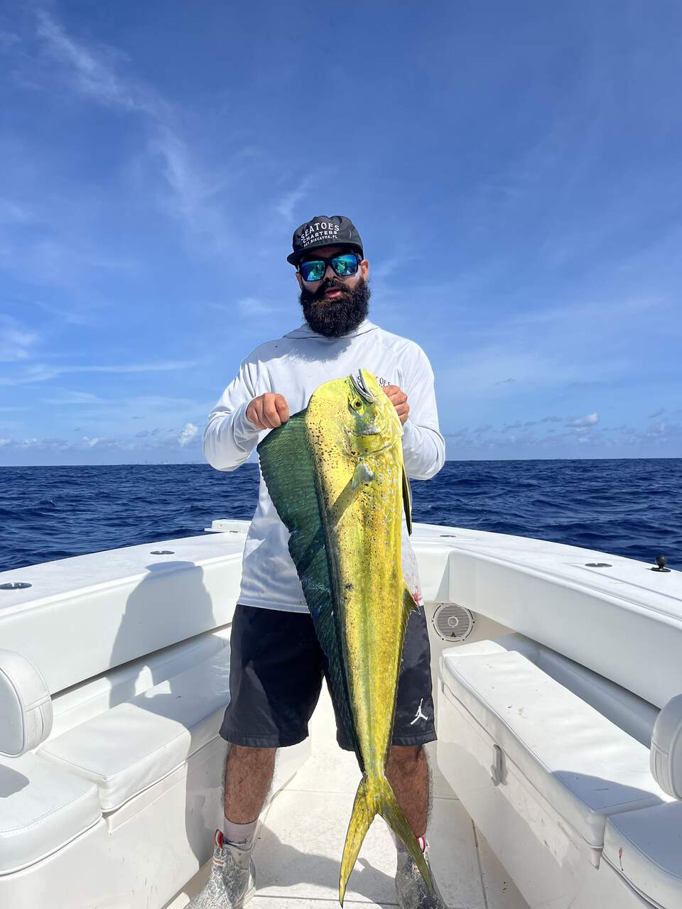 A person with a yellow fish on a boat in North Miami