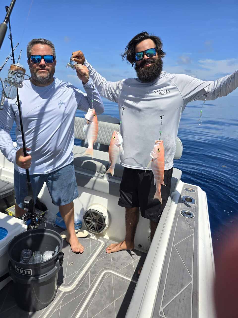 Two men displaying their fish on a Coral Gables charter